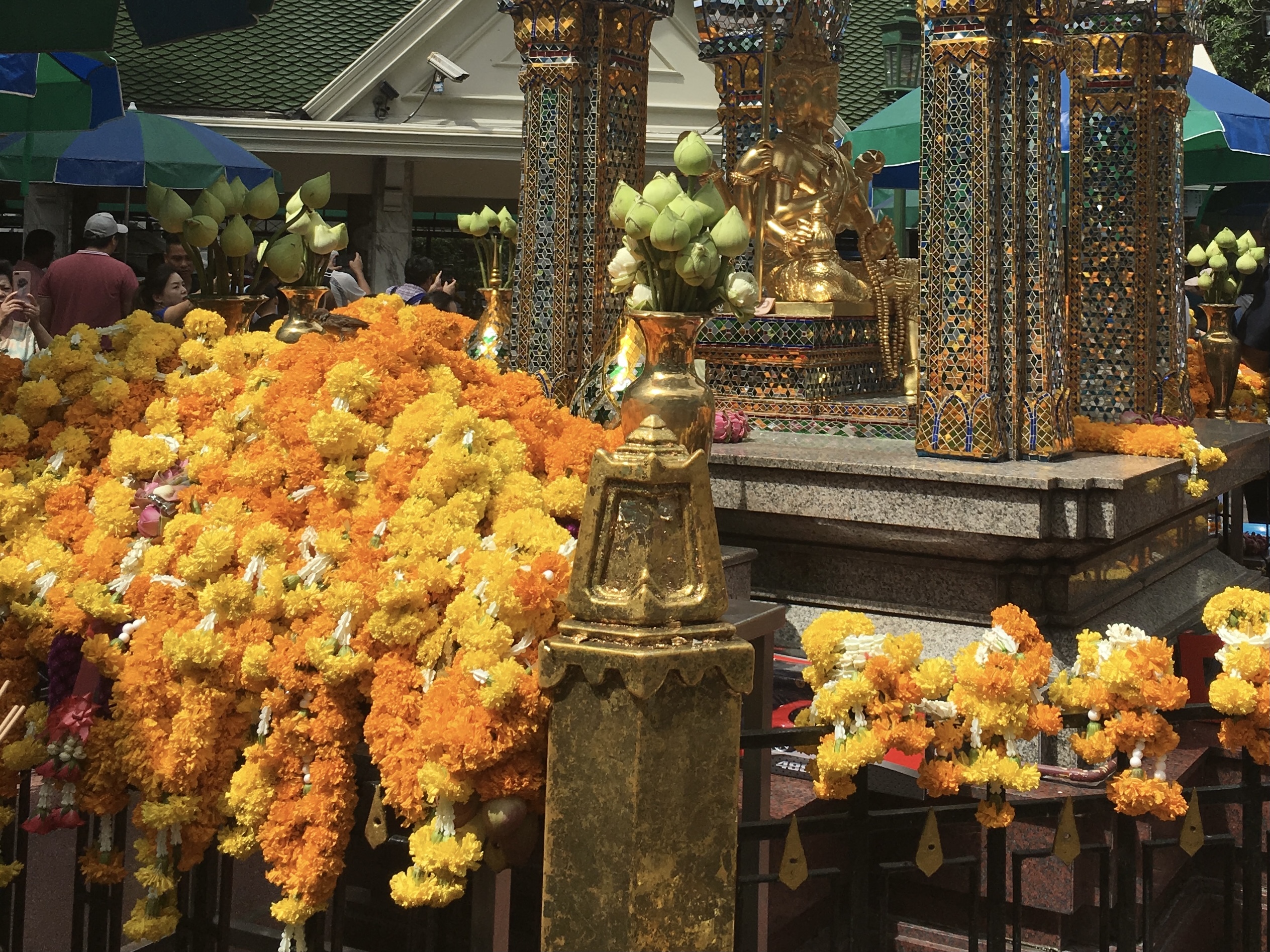 黄色とオレンジのマリーゴールドの花を、１メートル以上も繋ぎ合わせたガーランド状のものが渦高く供えられている。