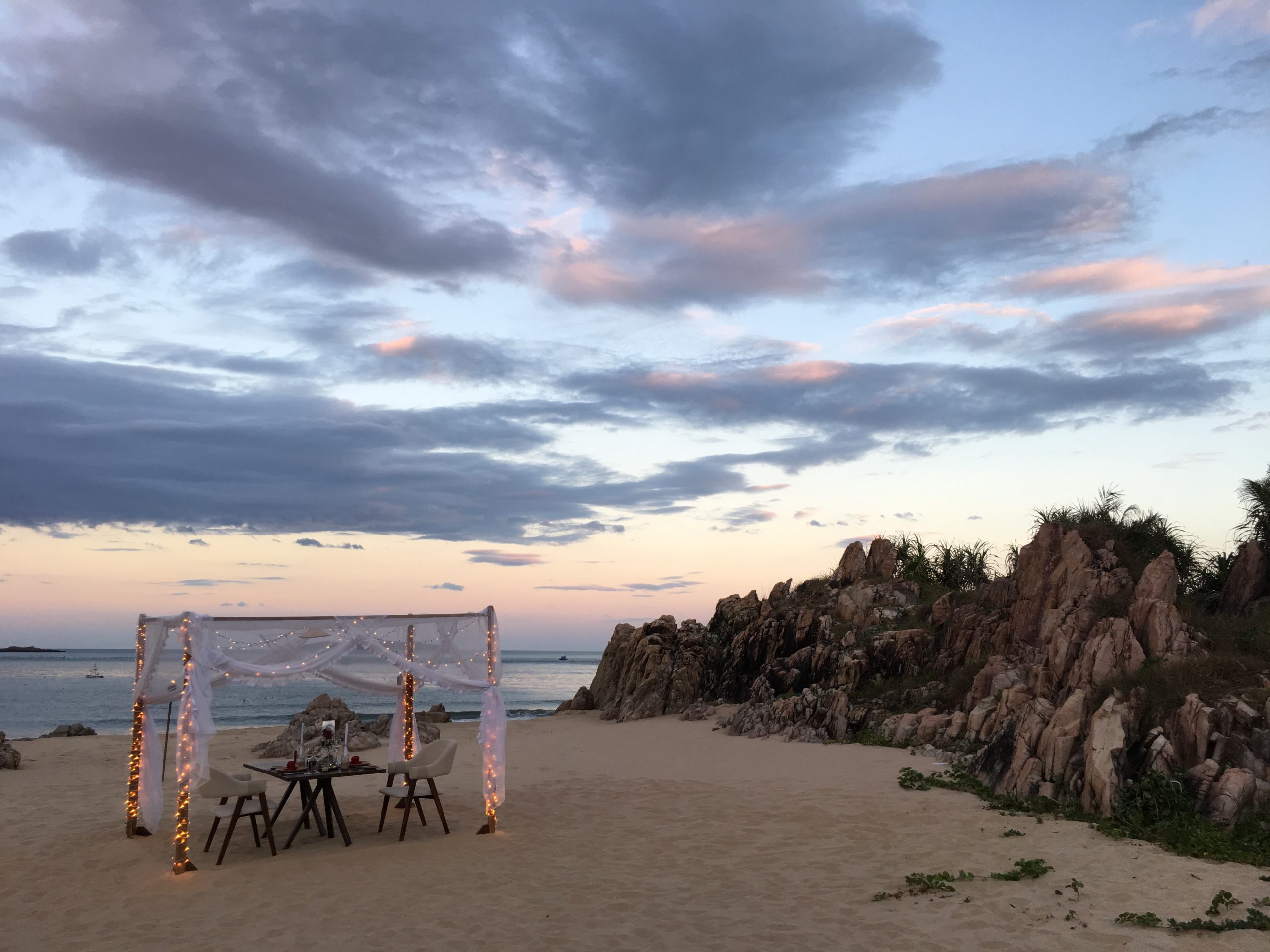 海を見晴らす岩陰に、プライベートなディナーテーブルをセッティング。バイセップビーチにある「アナンタラ　クイニョン ヴィラ」での特別アレンジ。