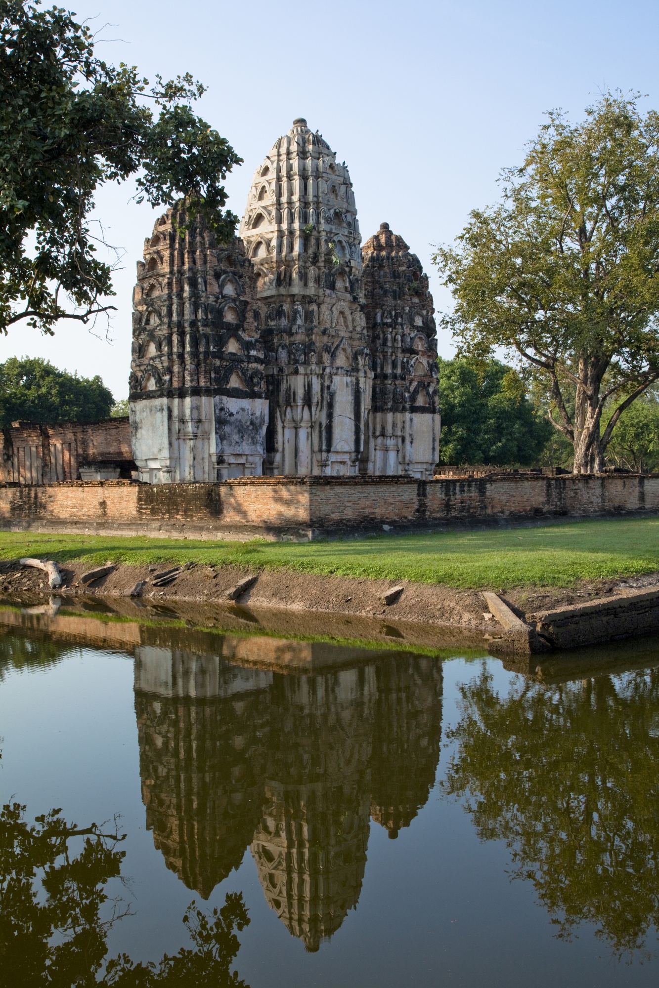 「ワット・シー・サワイ」。クメール時代にヒンドゥー教寺院として建てられたが、仏教寺院へと改められた。ラテライト（紅土）で造られ、囲いの中には重厚感のある3基の塔堂がそびえ立つ。