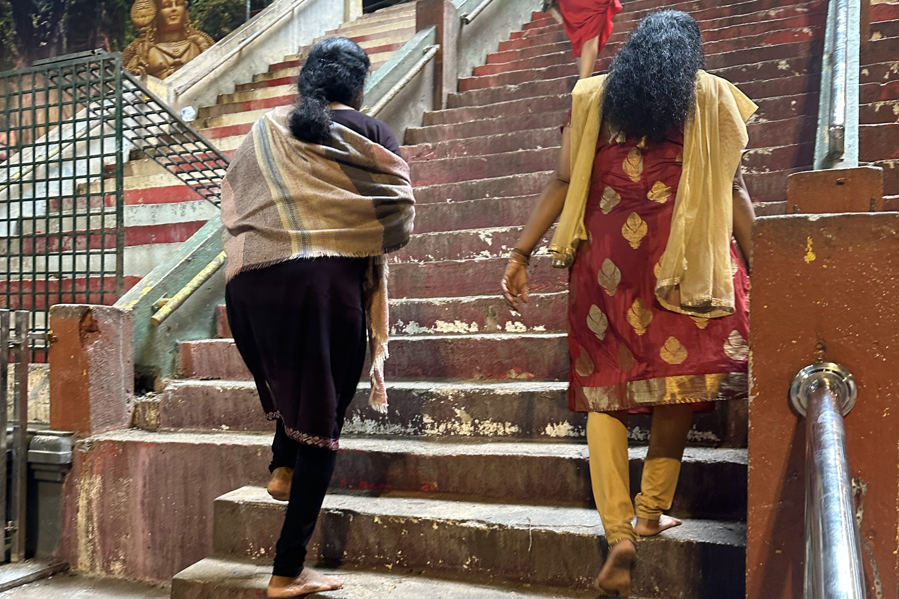 裸足で階段を上るサリー姿の女性。寺院は神が宿る場とされ、外の汚れを持ち込まないよう入り口で靴を脱ぐのが慣わしだそう