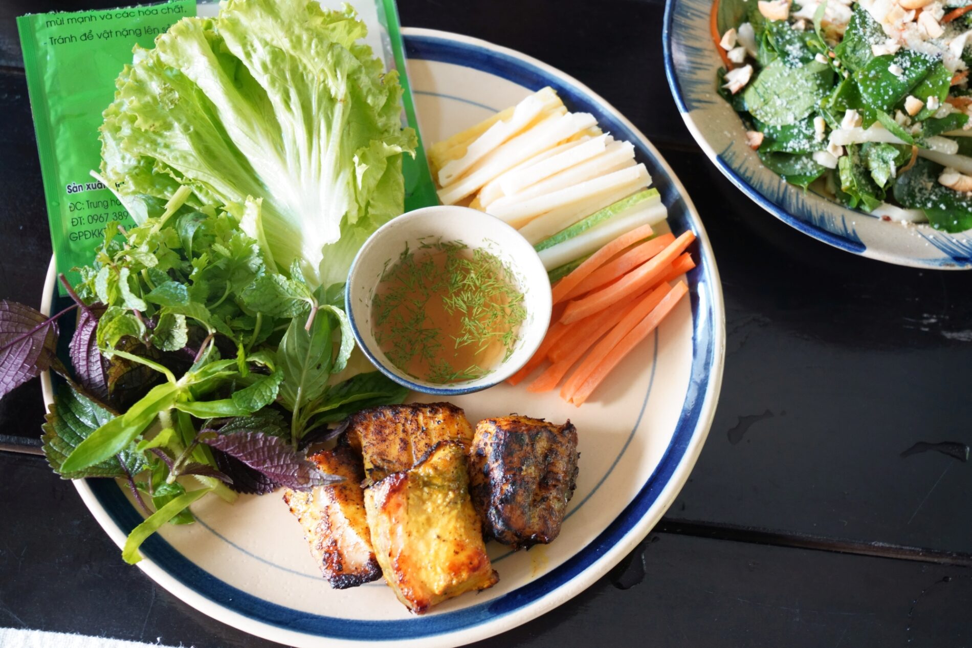 シャキシャキ食感のハスの茎と香ばしい焼き魚を、ハーブと一緒に包んで味わう一皿。