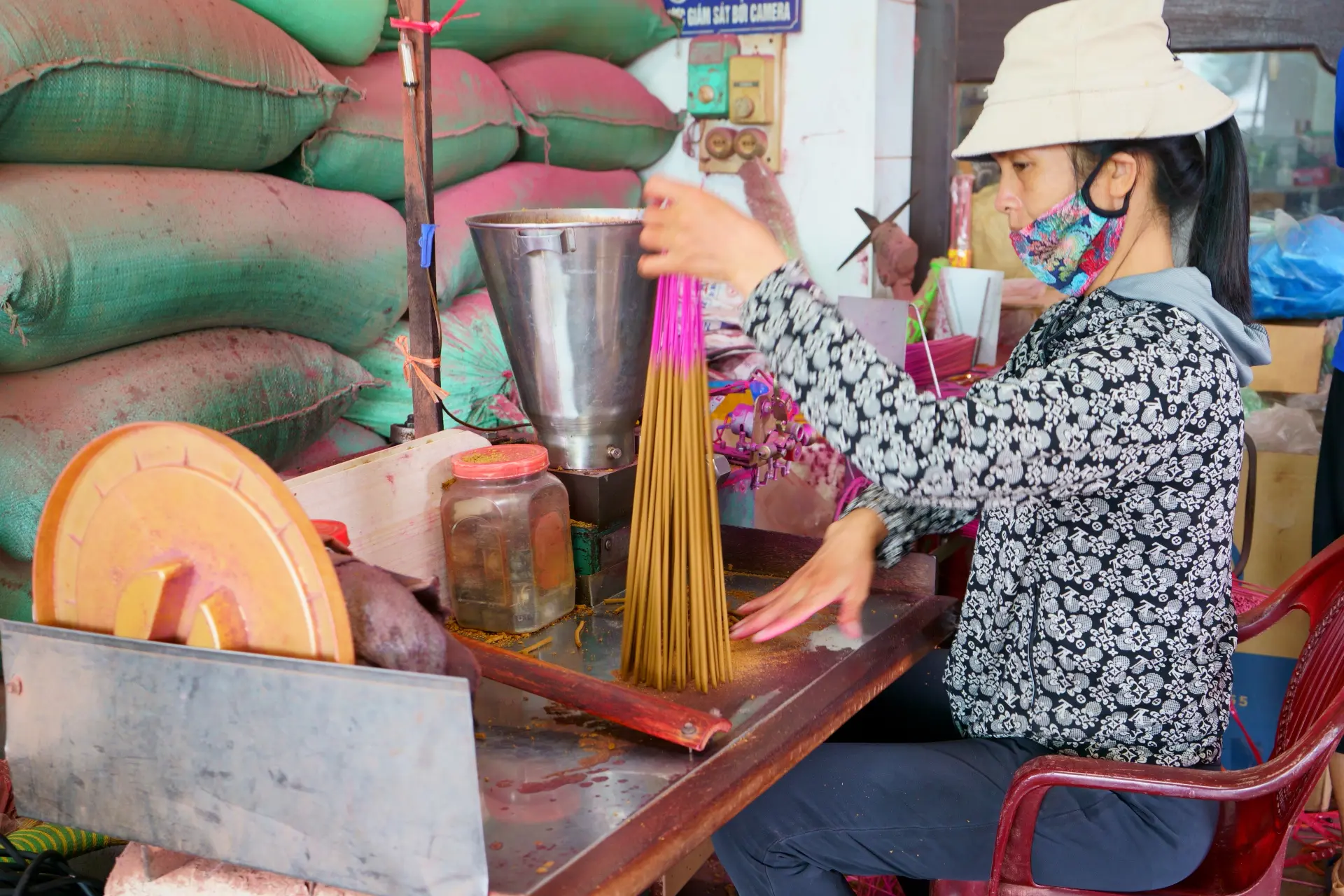 植物を使用した香料と可燃剤を粘土状にしたものを、機械を使って手早く芯材のまわりに塗っていく。